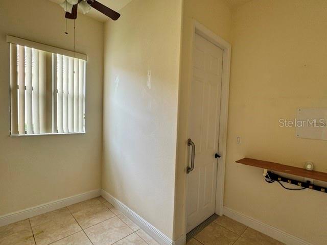 A room with tile flooring, a window with vertical blinds, a door, and a wall shelf — 896 BARCELONA DRIVE, POINCIANA, FL