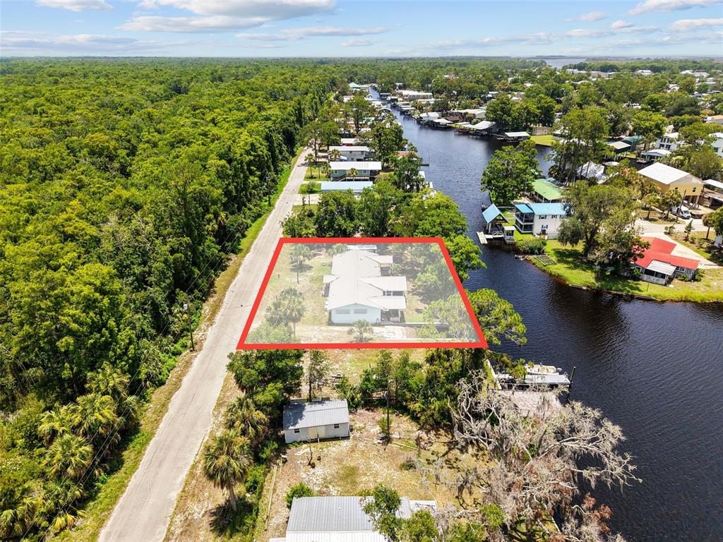 A light blue single-story house with a metal roof sits on a grassy lot — 306 SE 256 STREET, SUWANNEE, FL
