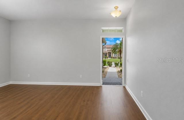 A green single-story house with a three-car garage and palm trees in the front yard — 2317 CROSSTON CIRCLE, ORLANDO, FL
