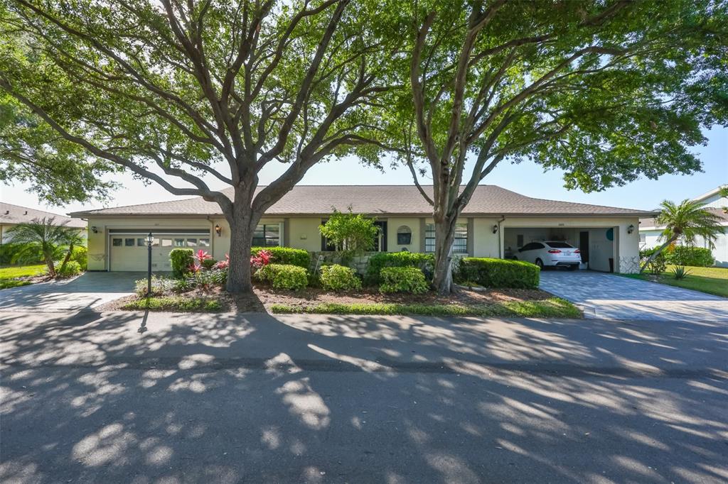 A green front door with decorative glass panels sits at the end of a tiled entryway — 2611 LANCASTER DRIVE UNIT 33, SUN CITY CENTER, FL
