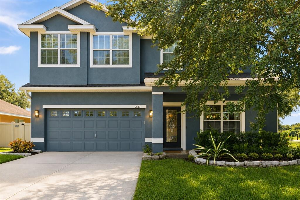 A two-story blue house with a two-car garage and a landscaped front yard — 9530 NATHANIEL LANE, LAND O LAKES, FL