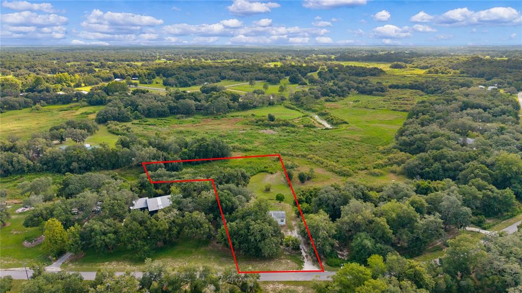 An aerial view shows a rural property outlined in red with a small house — 6590 CR 631, BUSHNELL, FL