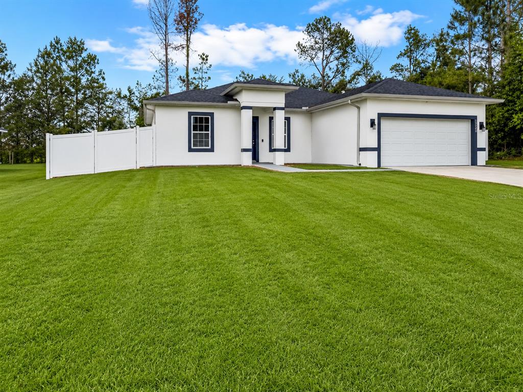 A living room with light wood floors, a grey sectional, and a sliding glass door — 13340 SW 49TH AVENUE, OCALA, FL