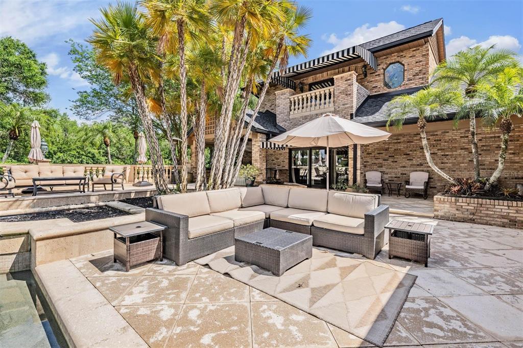 The exterior of a brick house features a large covered entryway with columns and pavers — 18707 PEPPER PIKE, LUTZ, FL