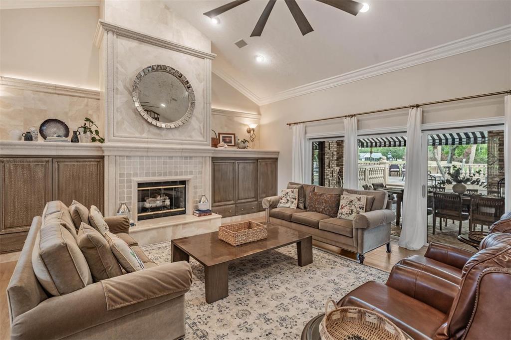 A grand foyer with a vaulted ceiling, stone floors, and columns leading into a living room — 18707 PEPPER PIKE, LUTZ, FL