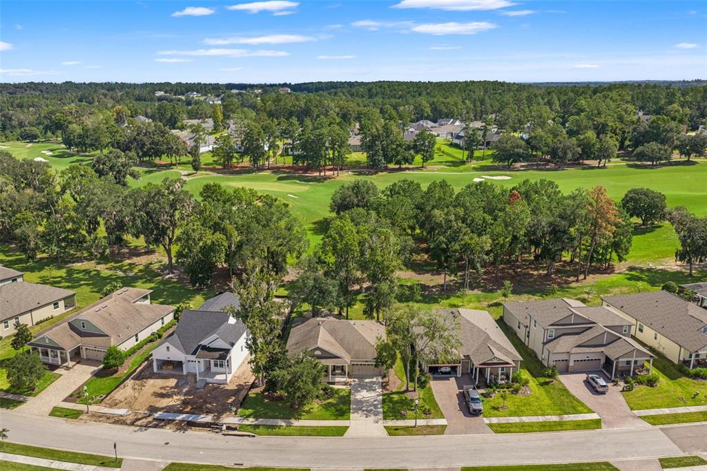 An aerial view shows a row of suburban houses bordering a large, green golf course — 4684 SOUTHERN VALLEY LOOP, BROOKSVILLE, FL