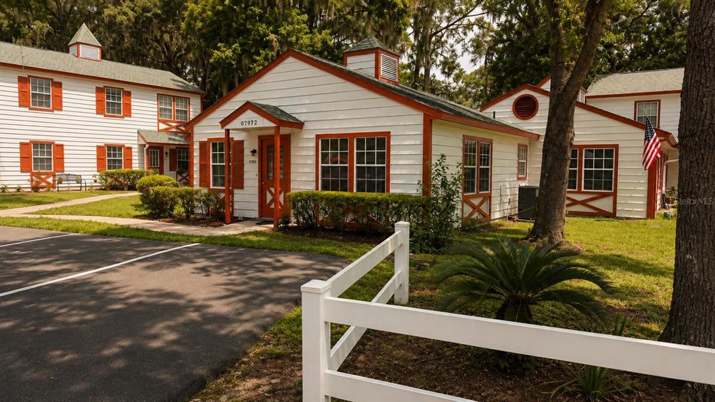 A white building with orange trim and a parking lot in front — 7972 MIDWAY DRIVE TERRACE UNIT O103, OCALA, FL