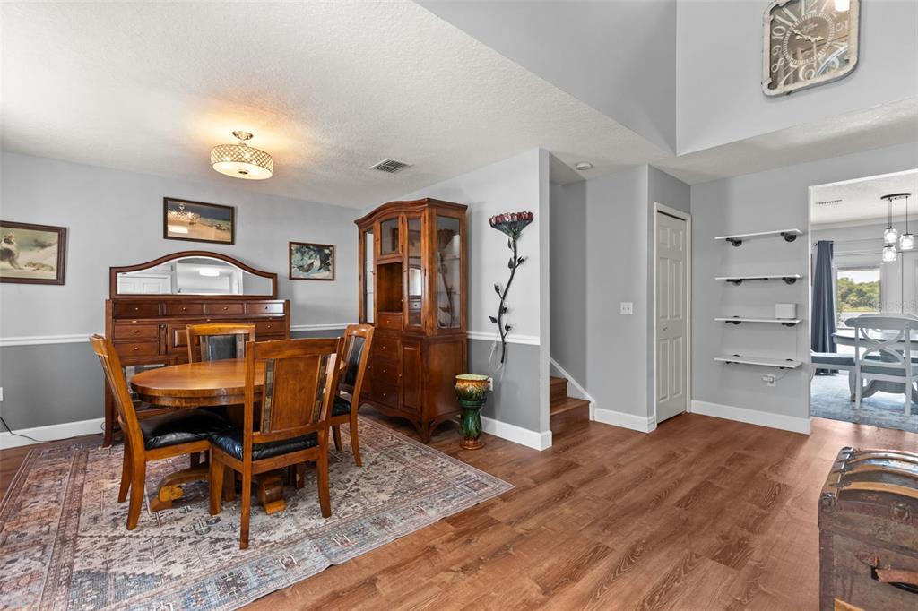 A dining room features a wooden table, a hutch, and open shelving on a gray wall — 302 LAKE SHEPARD DRIVE, APOPKA, FL