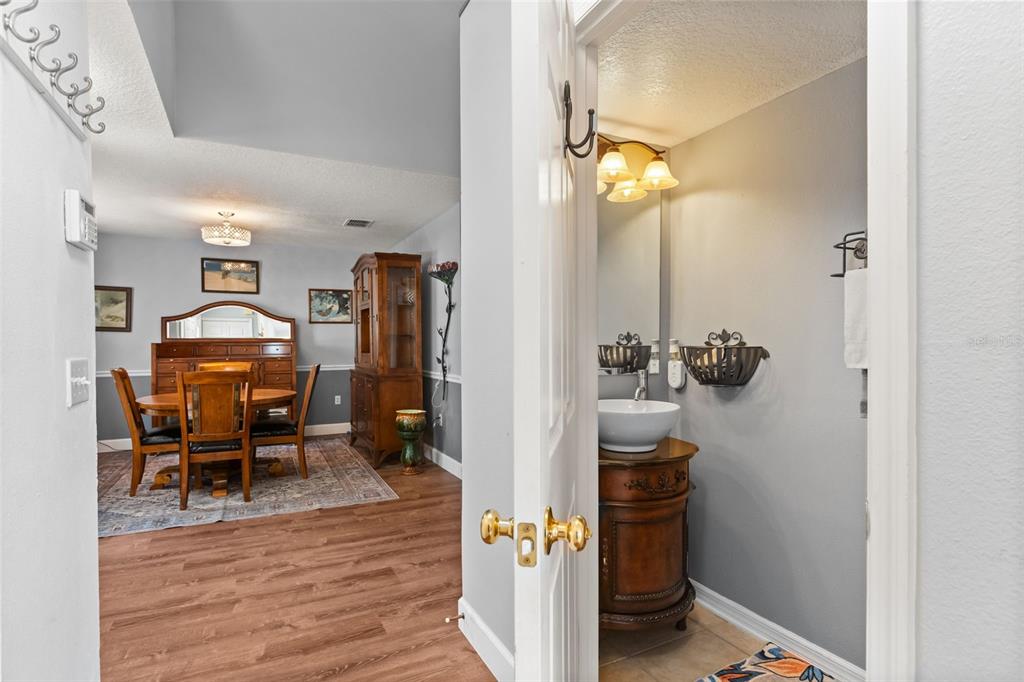 A view from a doorway looking into a dining room and a small powder room — 302 LAKE SHEPARD DRIVE, APOPKA, FL