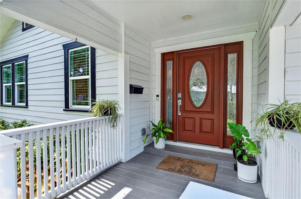 A living room features a dark gray sectional sofa, a patterned rug, and white doors — 2028 ILLINOIS STREET, ORLANDO, FL
