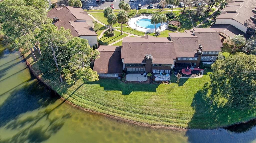 An aerial view of a multi-unit residential building with a pool and waterfront lawn — 637 MIDWAY DRIVE UNIT B, OCALA, FL