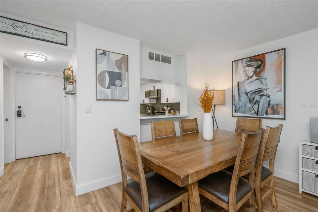 A bathroom features wood-paneled walls, a light wood vanity, and a wall-mounted cabinet with shelving — 2614 COVE CAY DRIVE UNIT 102, CLEARWATER, FL