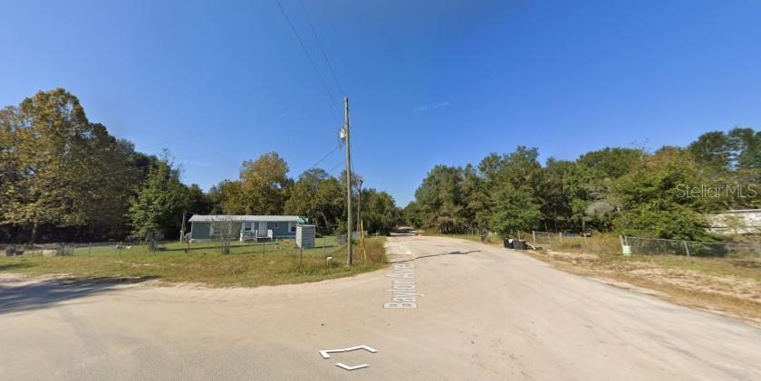 A single-story house sits on a corner lot at the intersection of two dirt roads — 6436 BAYLOR AVENUE, KEYSTONE HEIGHTS, FL