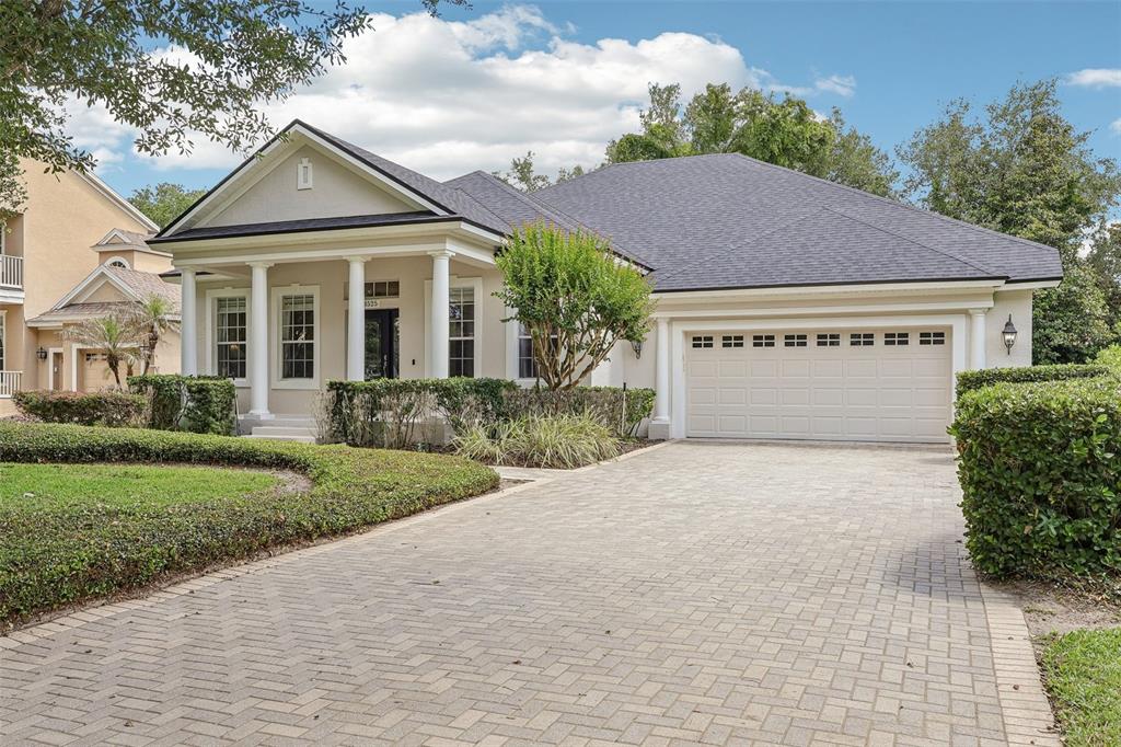 A single-story house with a paved driveway, a columned front porch, and a two-car garage — 8525 BOWDEN WAY, WINDERMERE, FL