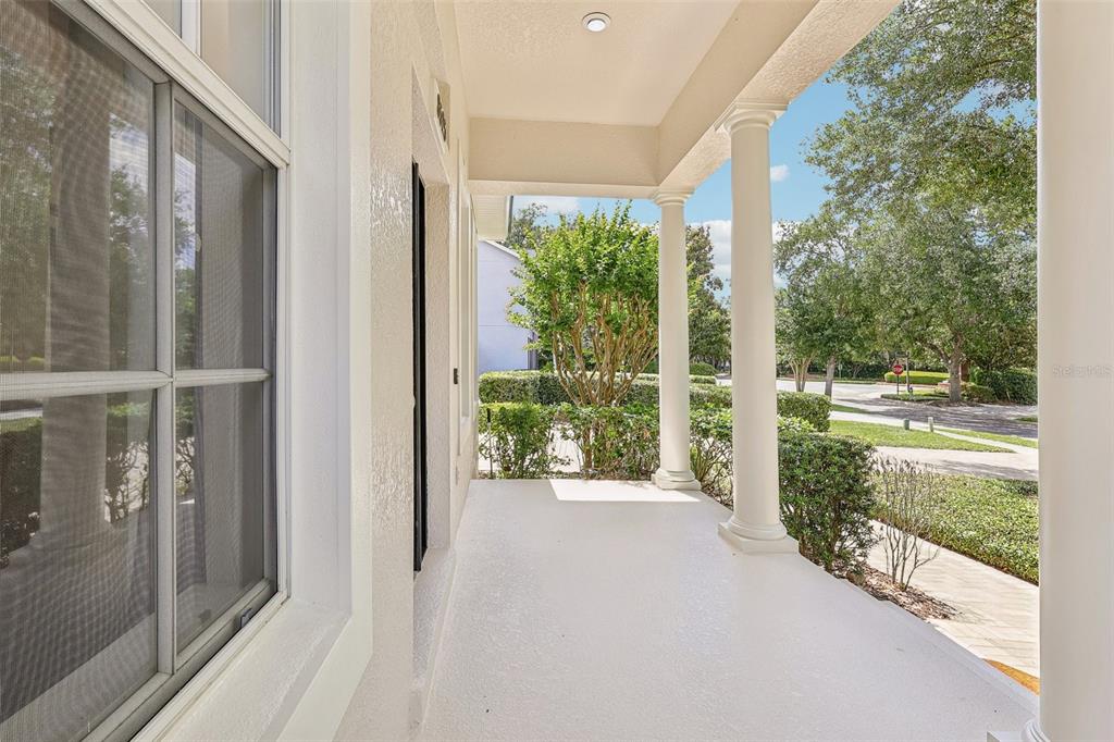 A covered front porch with white columns overlooks a landscaped neighborhood street — 8525 BOWDEN WAY, WINDERMERE, FL