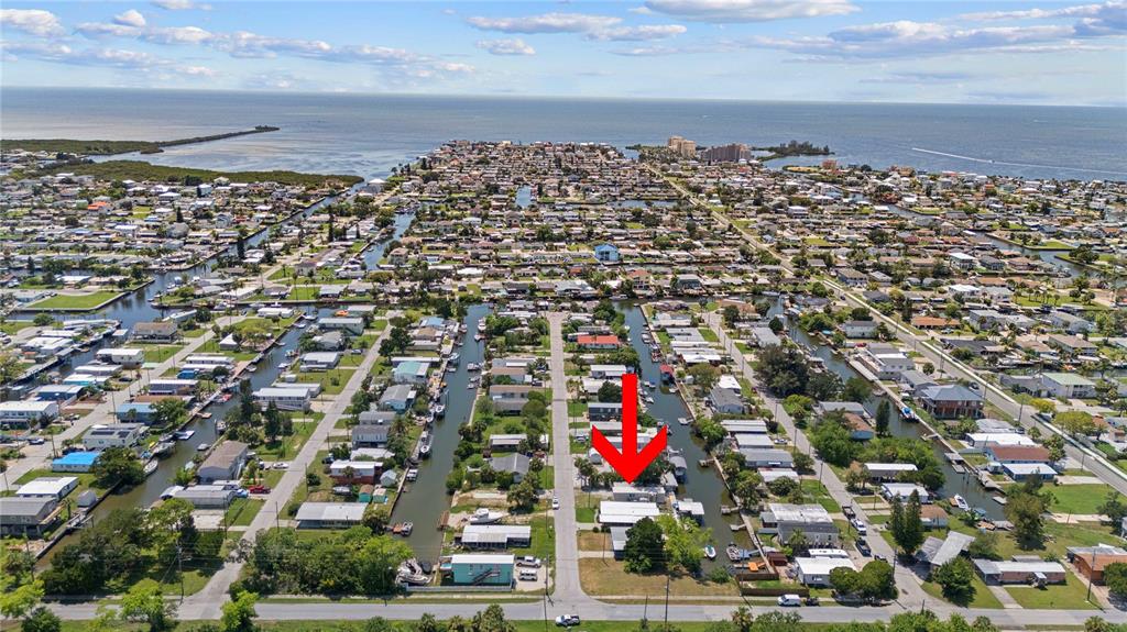 An aerial view shows a residential neighborhood with houses situated along multiple narrow canals — 6833 FLICKER LANE, HUDSON, FL