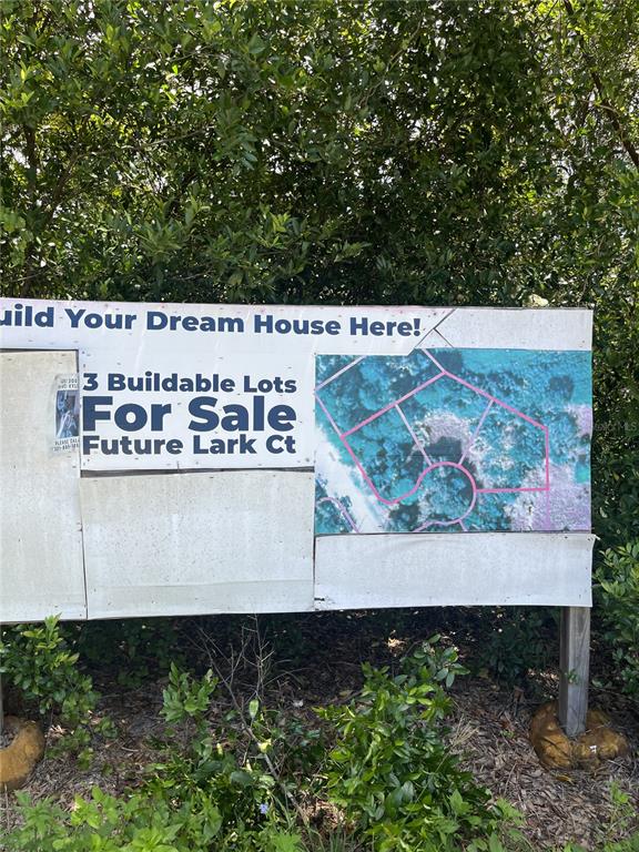 A sign displays a map of three buildable lots for sale on a future street — 847 LARK COURT, DELTONA, FL