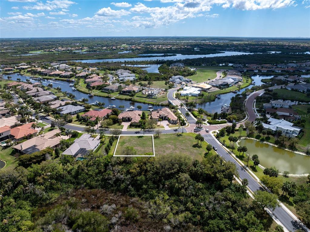 An aerial view shows a vacant rectangular residential lot surrounded by houses and waterways — 11708 RIVER SHORES TRAIL, PARRISH, FL