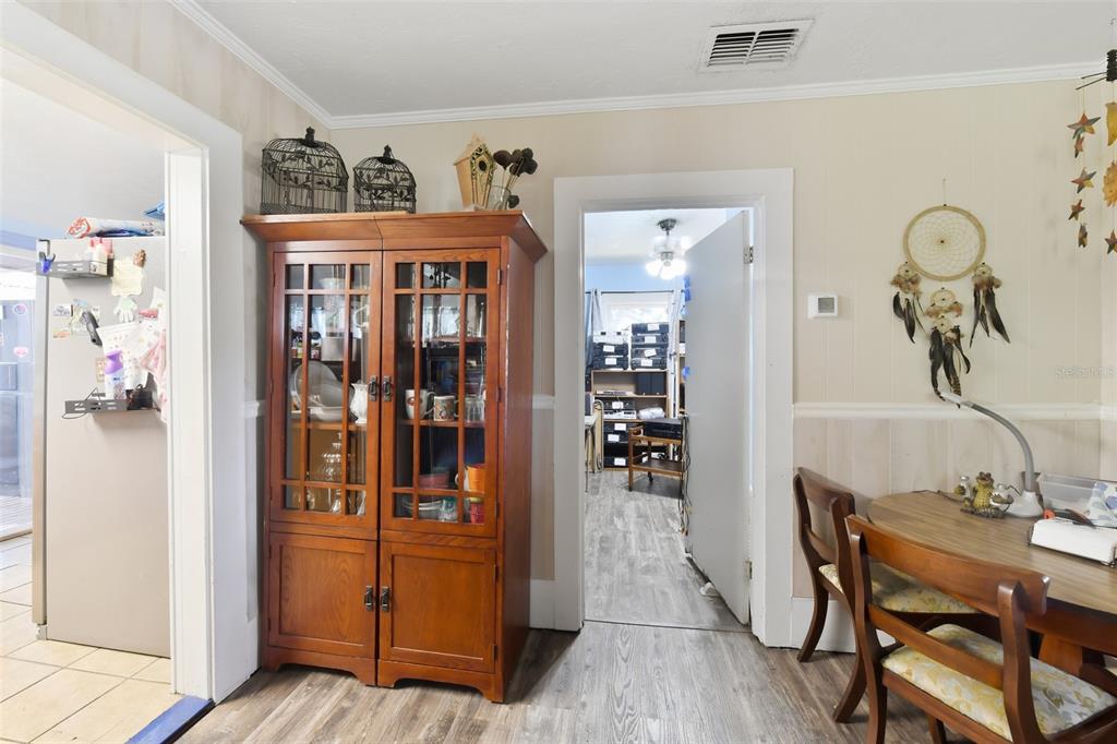 A dining area features a wooden hutch, a table with chairs, and a doorway entrance — 806 35TH STREET W, BRADENTON, FL