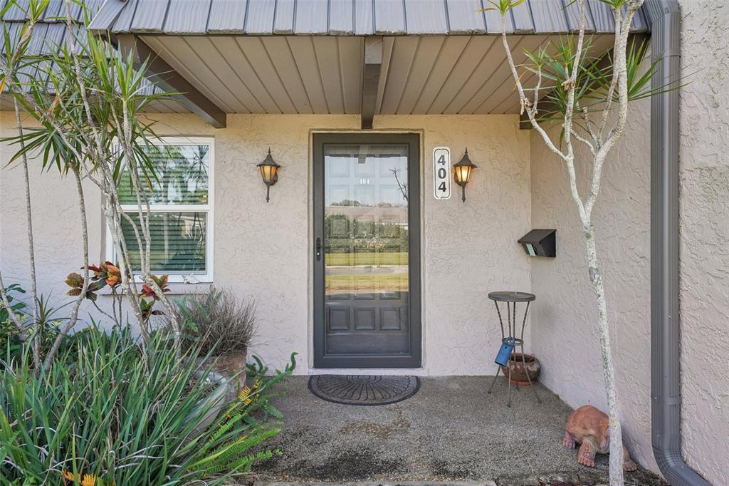 A stone archway entrance with the name Cordova stands before residential buildings and landscaping — 404 CORDOVA GREEN UNIT 404, SEMINOLE, FL