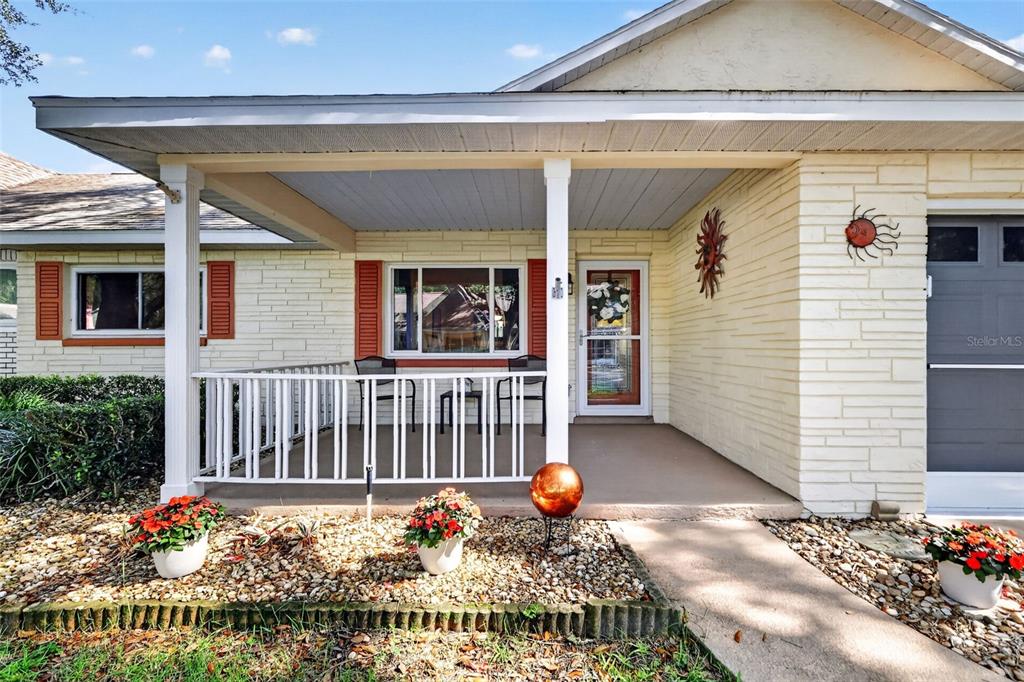A single-story house features a covered front porch with white railings and light-colored stone siding — 8591 SW 93RD PLACE UNIT C, OCALA, FL