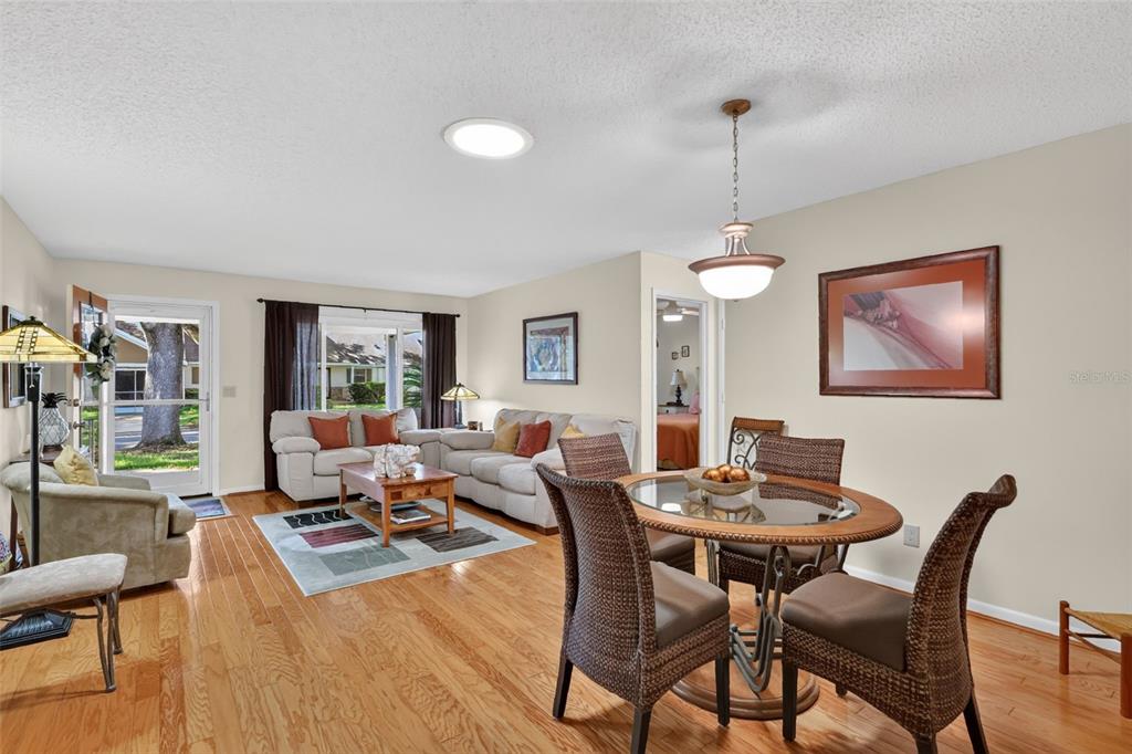 A living and dining area features hardwood floors, a glass-topped table, and a sectional sofa — 8591 SW 93RD PLACE UNIT C, OCALA, FL