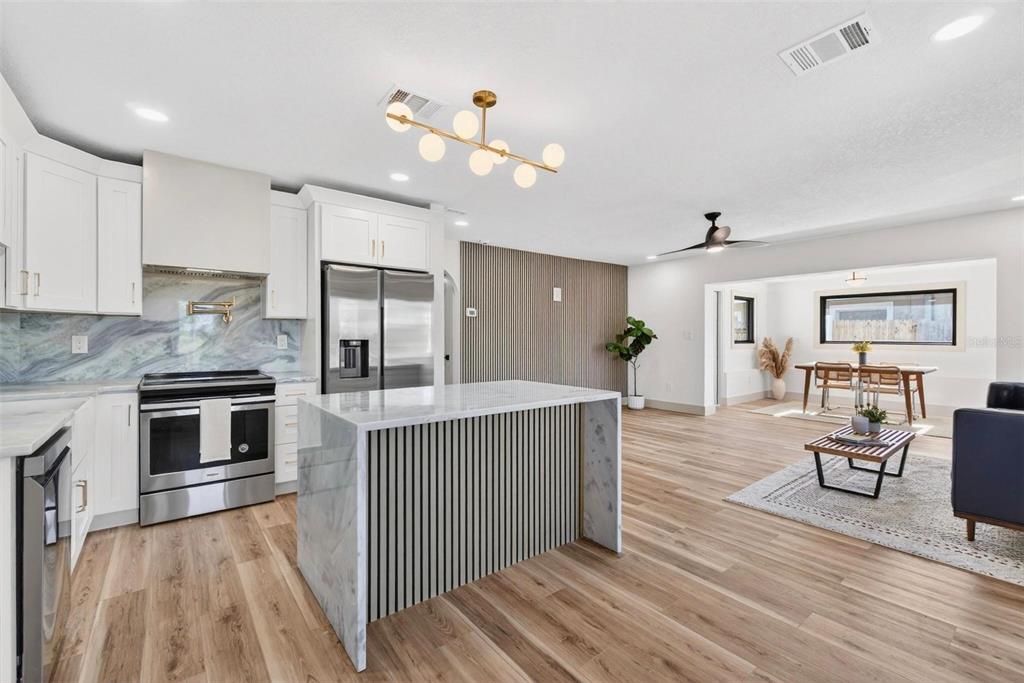 A dining room features a white table, four cane chairs, and three windows with black frames — 203 DRIFTWOOD DRIVE W, PALM HARBOR, FL