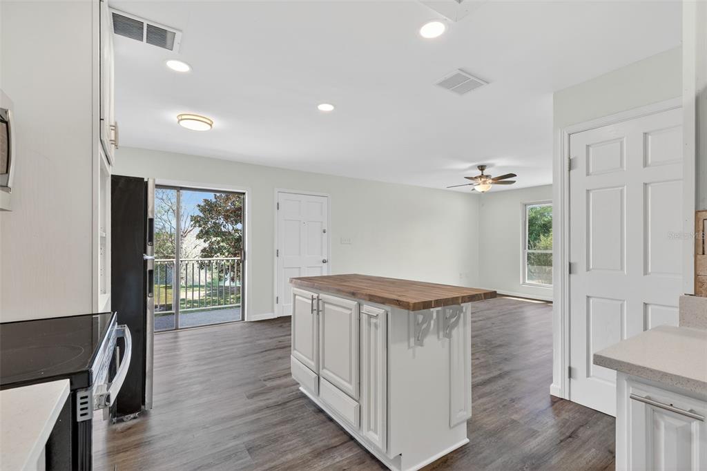 A balcony with a metal railing overlooks a grassy yard, a large tree, and water — 1935 CONWAY ROAD UNIT F6, ORLANDO, FL