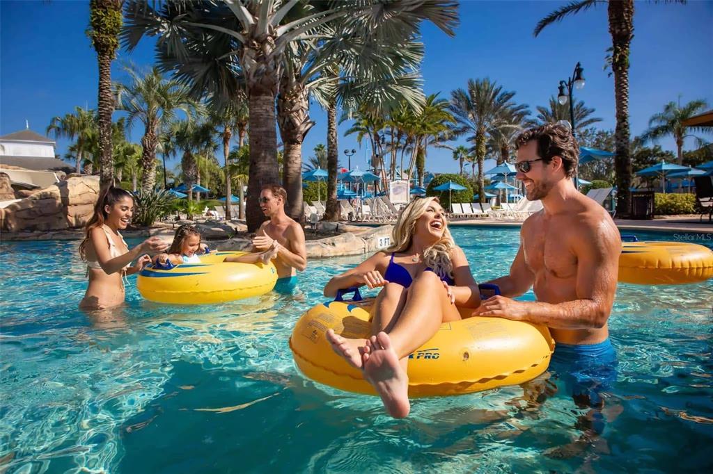 People enjoy a sunny day in a resort swimming pool with yellow inner tubes — 7921 SPECTRUM DRIVE, KISSIMMEE, FL
