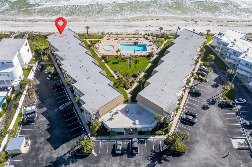An aerial view shows two multi-story beachfront buildings with a central pool and parking lots — 7900 A1A S UNIT A214, ST AUGUSTINE, FL