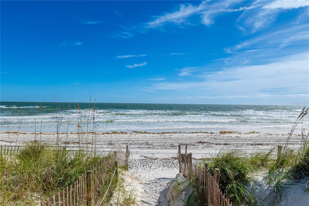 A sandy path leads through a wooden fence to a beach with ocean waves — 7900 A1A S UNIT A214, ST AUGUSTINE, FL