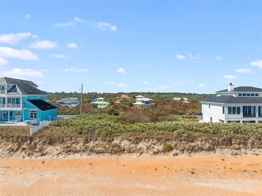 An exterior view of a sandy beach with a dune and several coastal houses nearby — 3101 N OCEAN SHORE BOULEVARD, FLAGLER BEACH, FL
