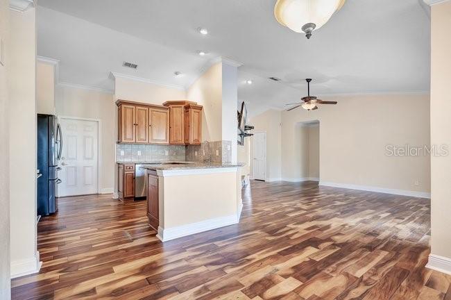 A living room features wood-look tile flooring, a stone fireplace, and an open kitchen — 4512 BRIDGEWATER DRIVE, ORLANDO, FL