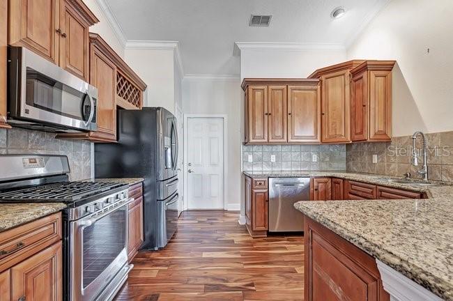 A room with wood-look flooring, a hanging light fixture, and large windows overlooking a pool — 4512 BRIDGEWATER DRIVE, ORLANDO, FL