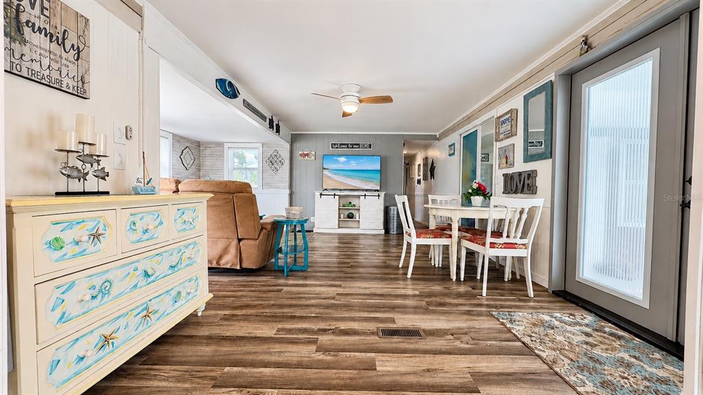 A white mobile home with blue trim features a covered entryway, landscaping, and a driveway — 6965 APOPO COURT, NORTH PORT, FL
