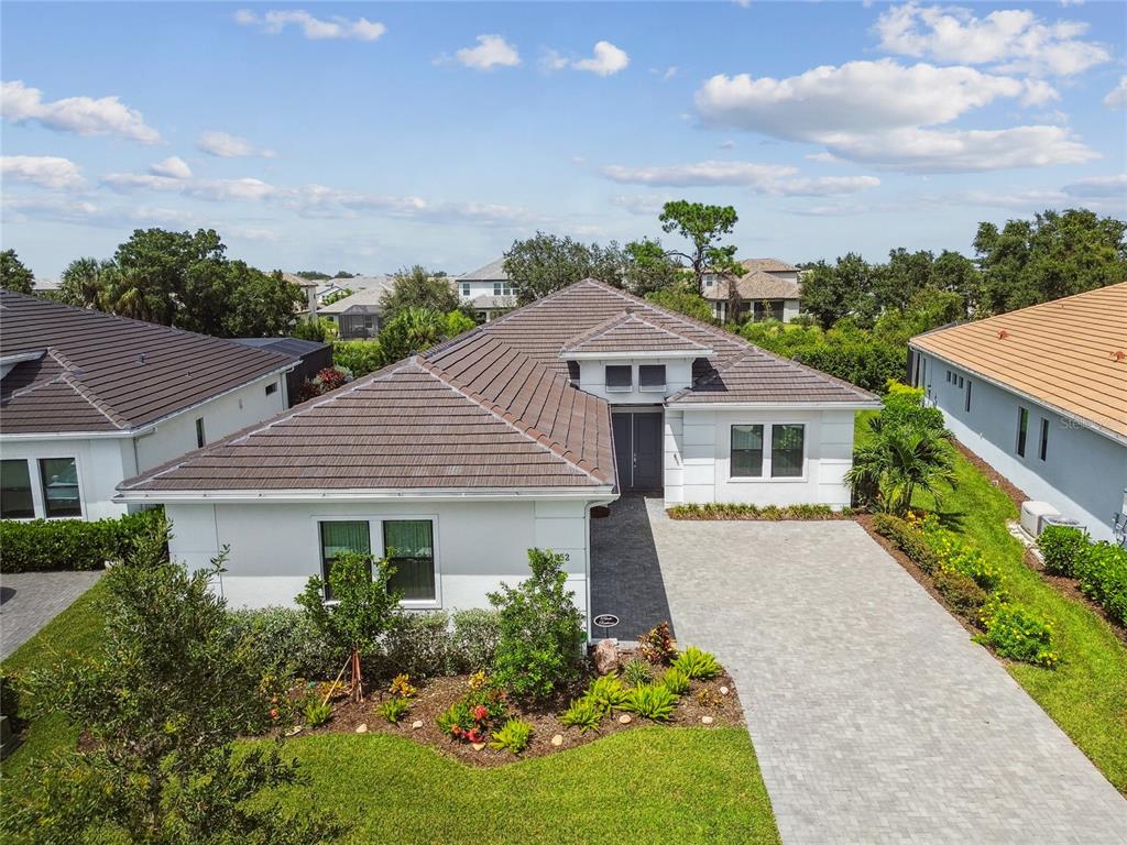 An aerial view of a single-story house with a tiled roof and paved driveway — 4952 SURFSIDE CIRCLE, BRADENTON, FL