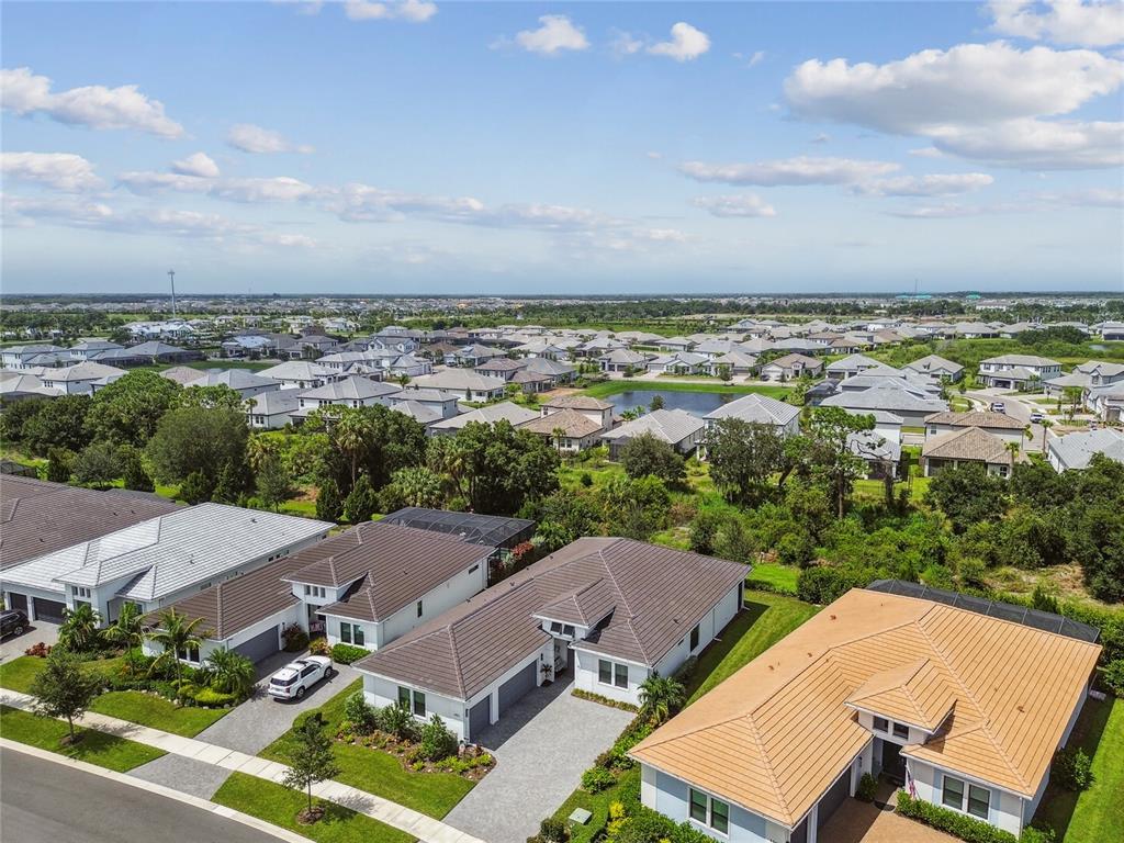 An aerial view shows several suburban houses with tiled roofs and driveways in a neighborhood — 4952 SURFSIDE CIRCLE, BRADENTON, FL