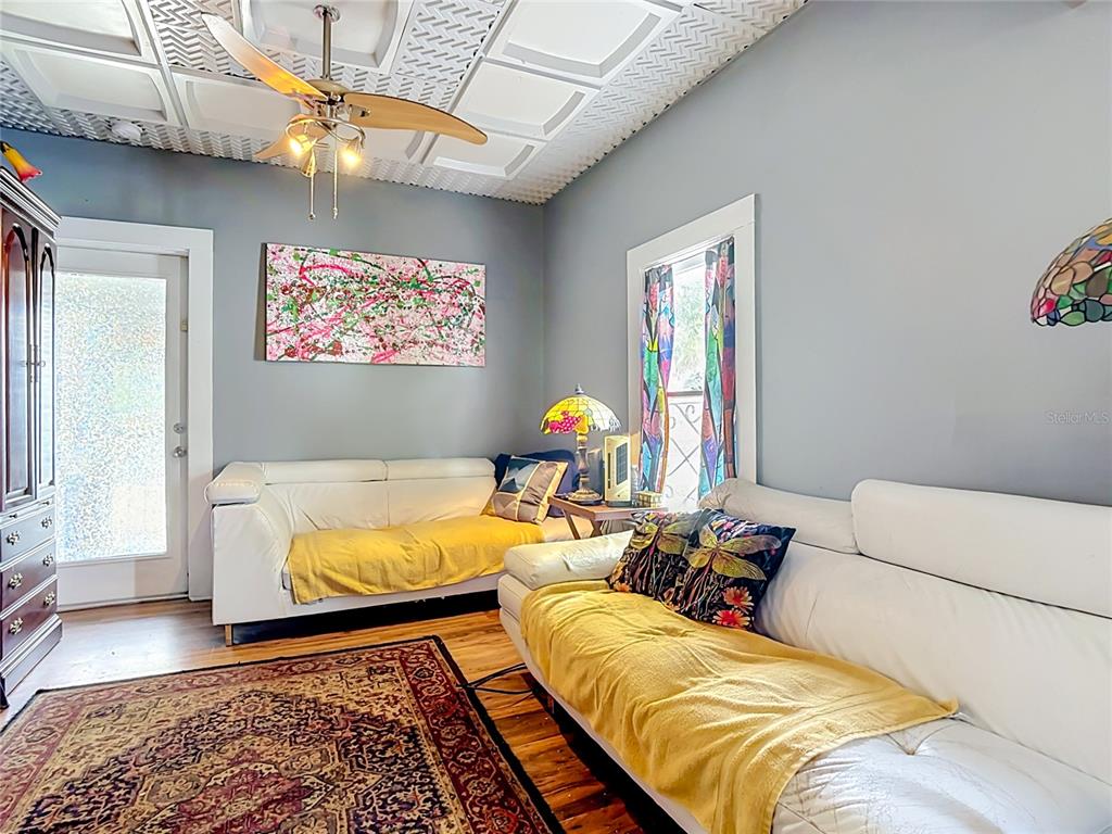 A living room features white leather sofas, a patterned rug, and a textured ceiling — 1417 11TH STREET, ST CLOUD, FL