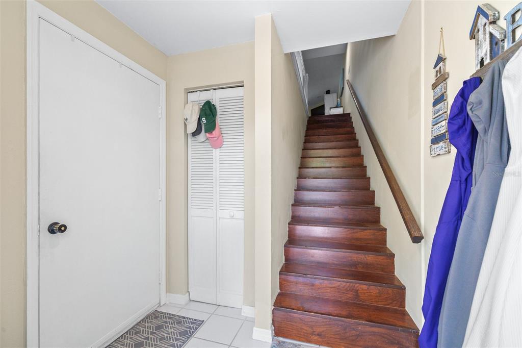 An entryway features a white door, a louvered closet, and wooden stairs leading upward — 751 PINELLAS BAYWAY S UNIT 208, TIERRA VERDE, FL