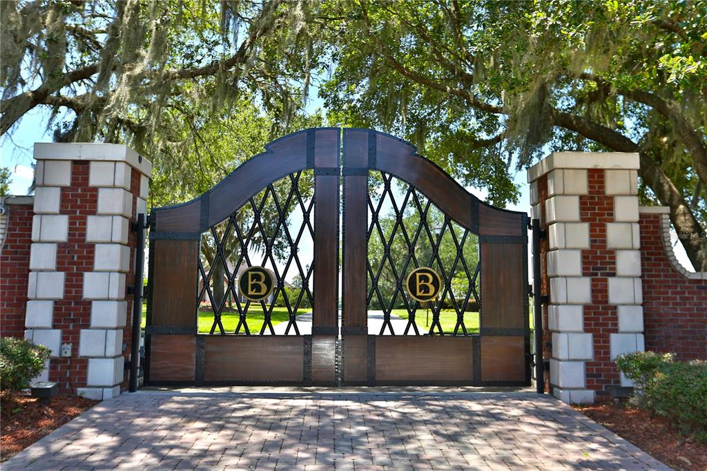A large wooden and metal gate with the letter B stands between two brick pillars — 6500A NW 193RD STREET UNIT Option 1, MICANOPY, FL