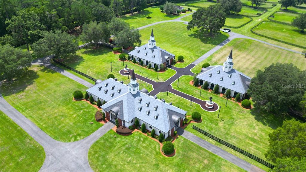 An aerial view shows three buildings with cupolas connected by paved walkways on a grassy estate — 6500A NW 193RD STREET UNIT Option 1, MICANOPY, FL
