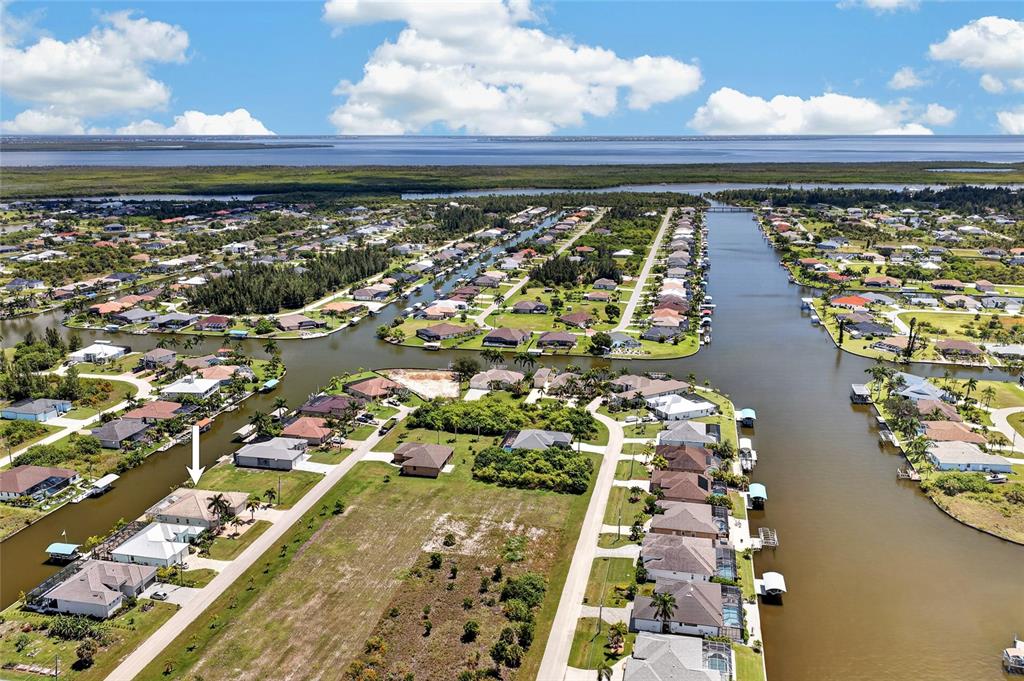 An aerial view shows a residential neighborhood with houses situated along interconnected canals — 15140 ALSASK CIRCLE, PORT CHARLOTTE, FL