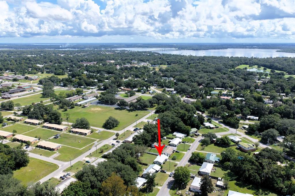 An aerial view shows a residential neighborhood with a red arrow pointing to a house — 1508 ROSELLE AVENUE, PALATKA, FL