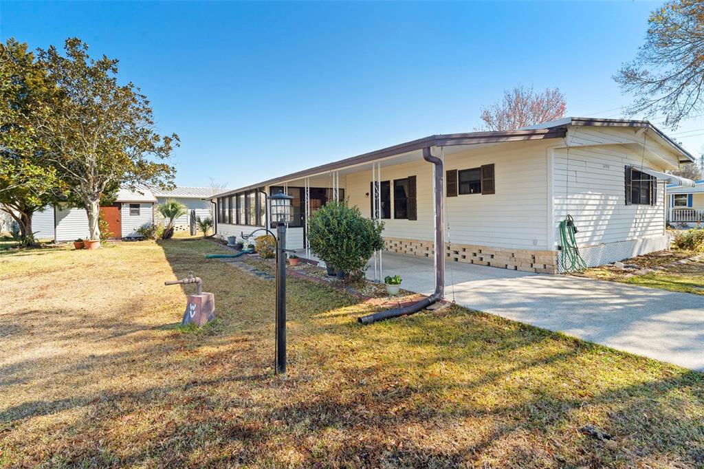 A kitchen features wood cabinets, laminate countertops, stainless steel appliances, and wood-look flooring — 232 MEADOW LARK DRIVE, OSTEEN, FL