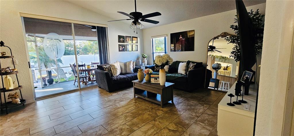 A living room features tile flooring, a ceiling fan, a sofa, and a sliding glass door — 2068 PREYMORE STREET, OSPREY, FL