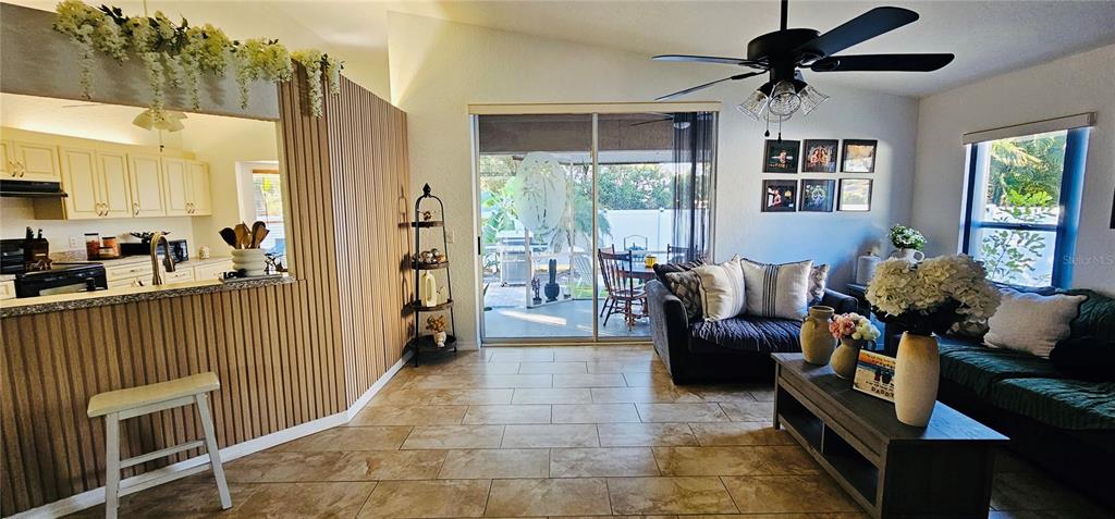 A living room features tile floors, a ceiling fan, and a view of a patio — 2068 PREYMORE STREET, OSPREY, FL