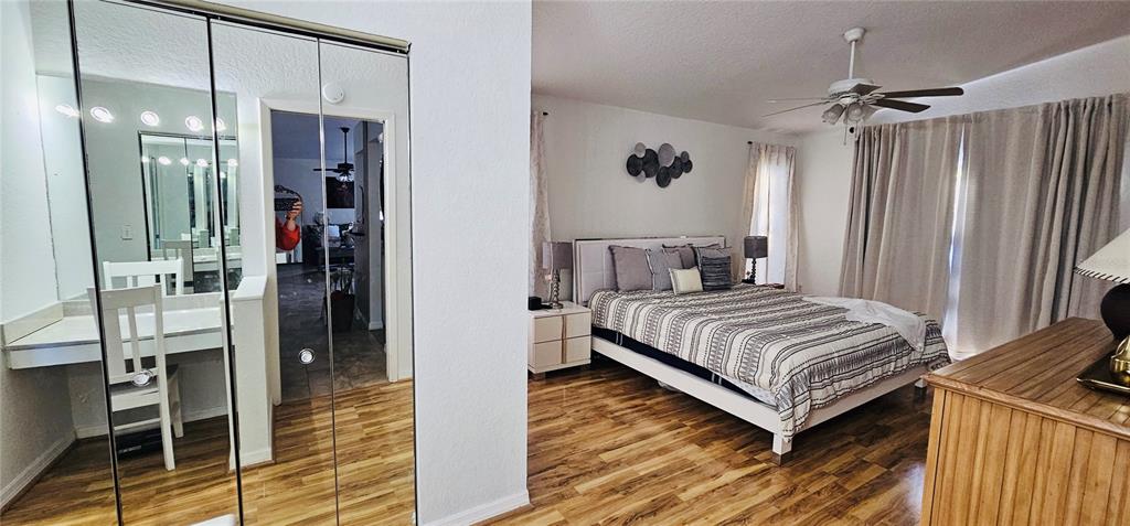 A bedroom features a bed, a vanity area with a mirror, and wood-look flooring — 2068 PREYMORE STREET, OSPREY, FL