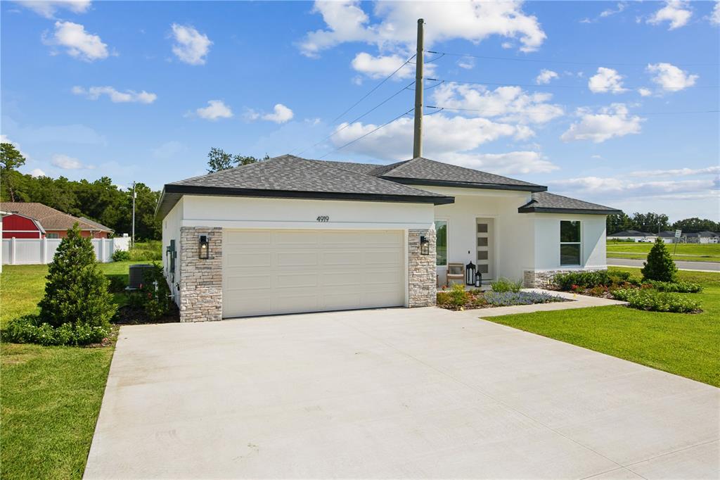 A single-story house with a white stucco facade, stone accents, and a two-car garage — 17 BONNIE LANE, PALM COAST, FL