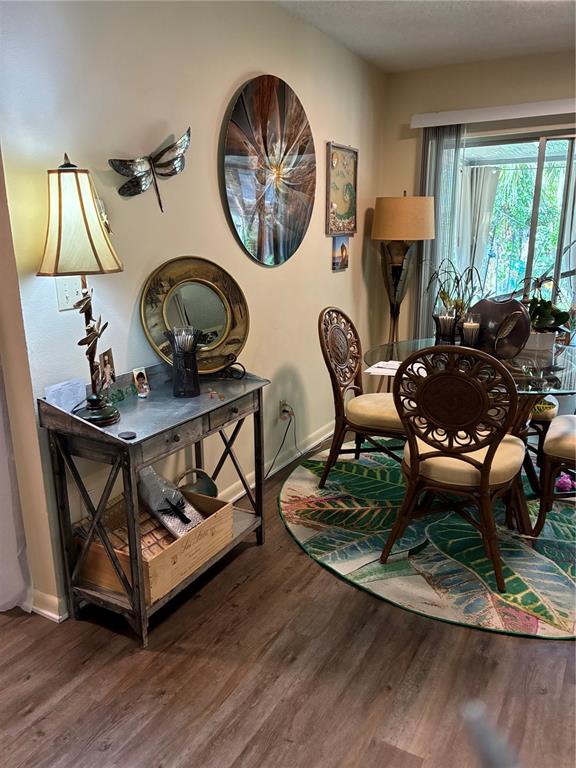 A dining area features a metal console table, a glass-topped table, and tropical-themed decor — 142 S SIMPSON STREET, MOUNT DORA, FL