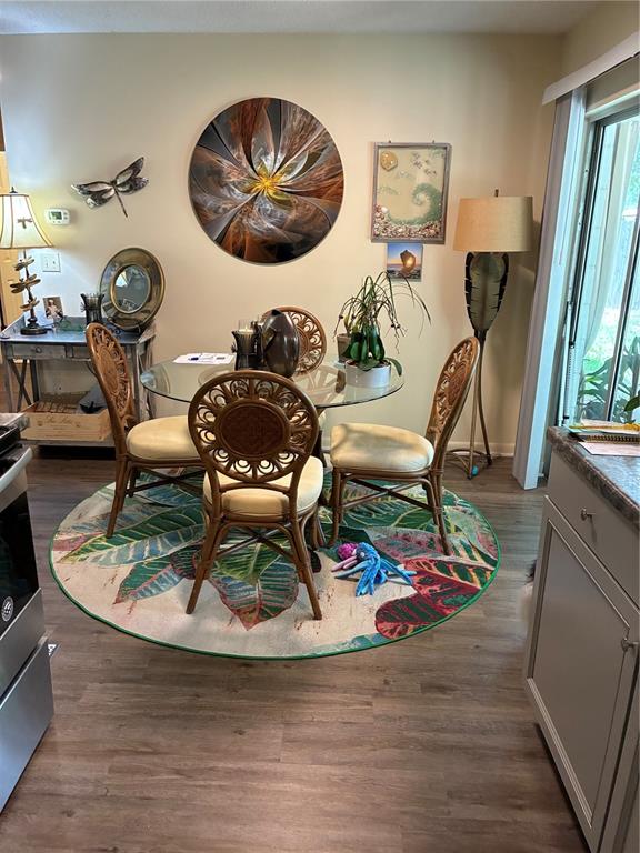 A dining area features a glass table, rattan chairs, a circular rug, and wall decor — 142 S SIMPSON STREET, MOUNT DORA, FL